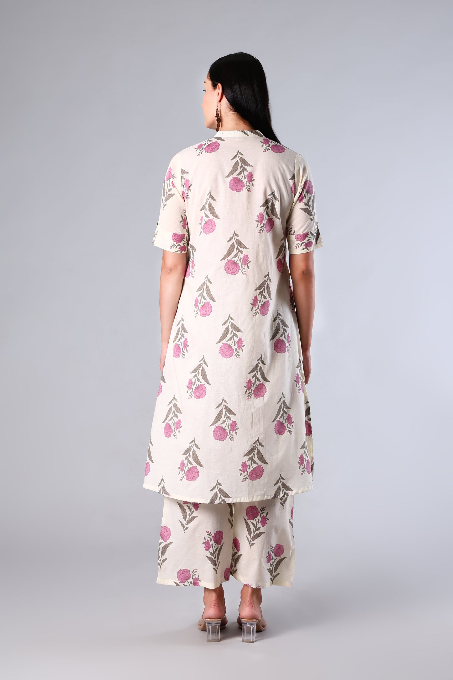 Woman wearing a Pink  floral kurta with pants on a gray background