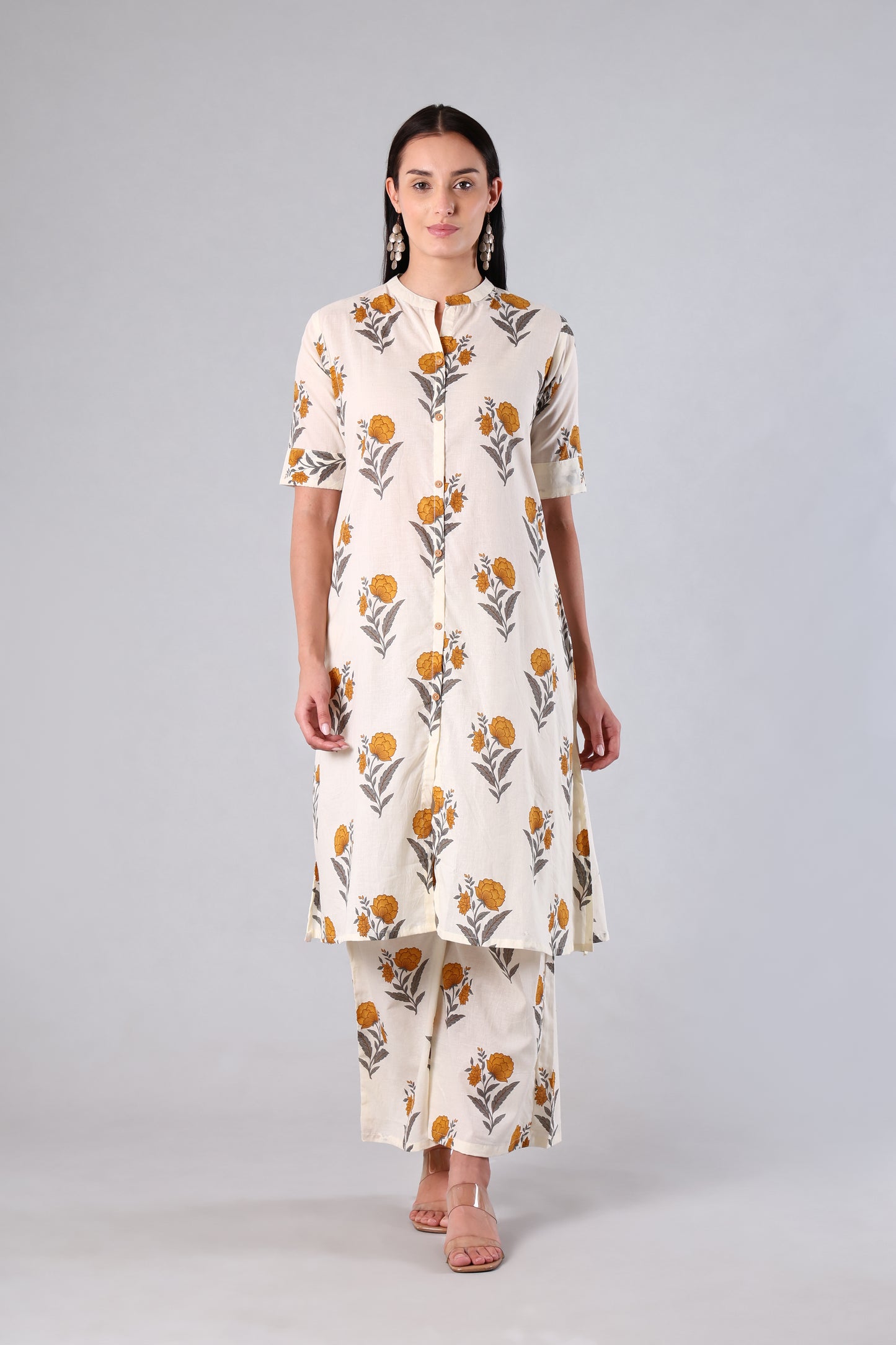 Woman wearing a Yellow floral printed kurta with pants on a gray background