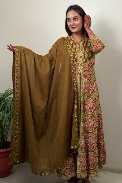 Woman wearing a traditional brown and pink embroidered outfit with a matching dupatta.