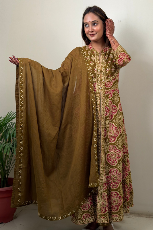 Woman wearing a traditional brown and pink embroidered outfit with a matching dupatta.