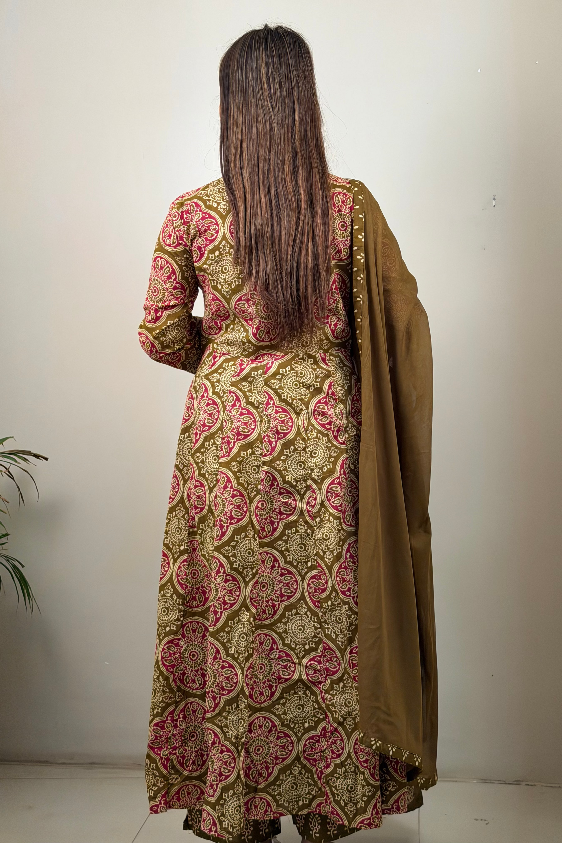 Woman wearing a patterned dress with a plain background