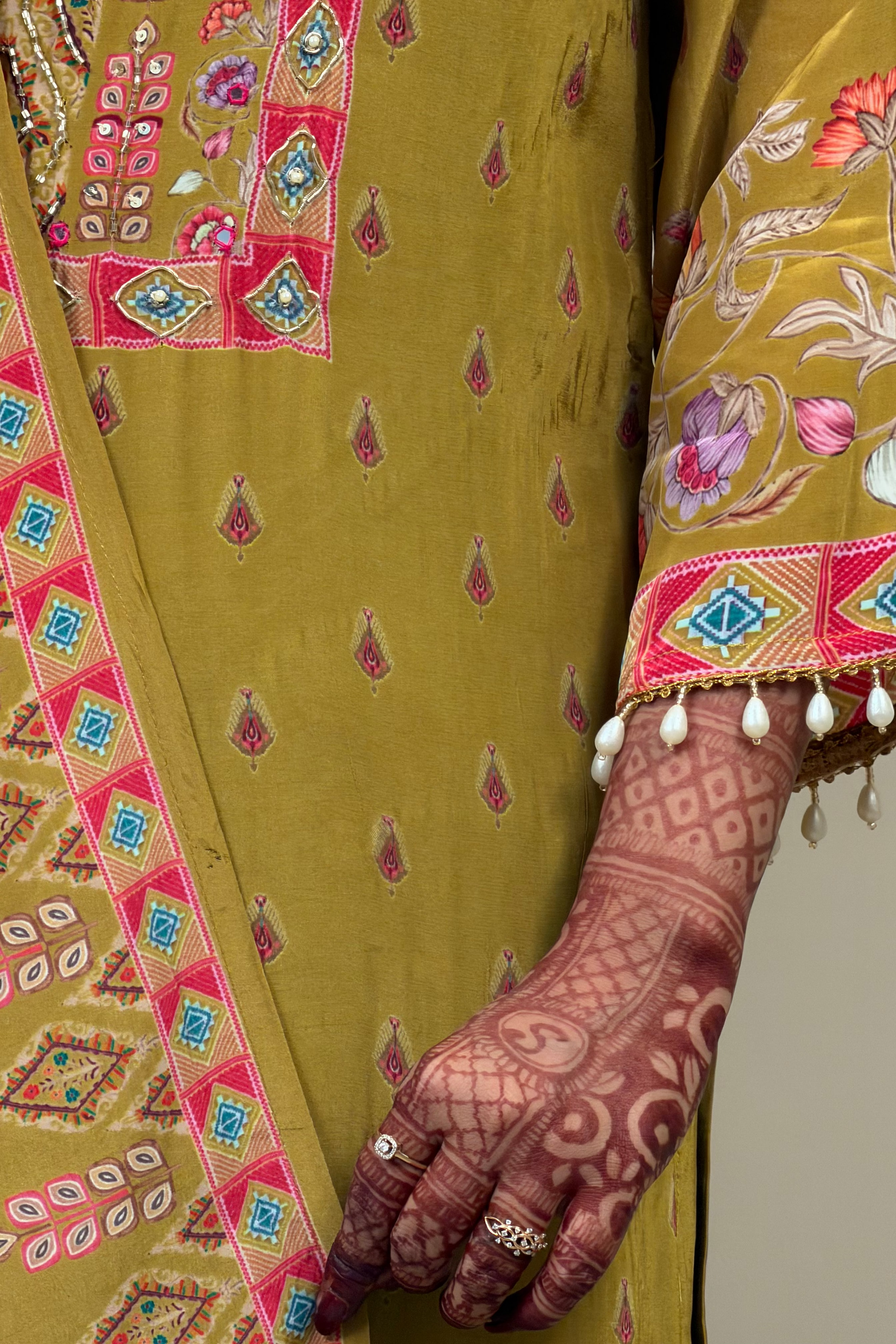 Close-up of a person wearing a traditional embroidered garment with intricate designs.