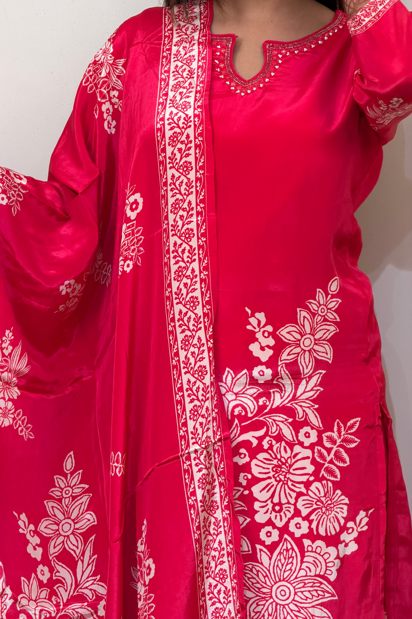 Red traditional outfit with white floral patterns on a plain background