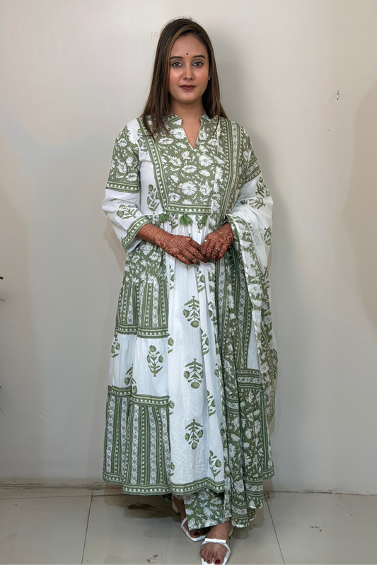 Woman wearing a green and white patterned dress against a plain background